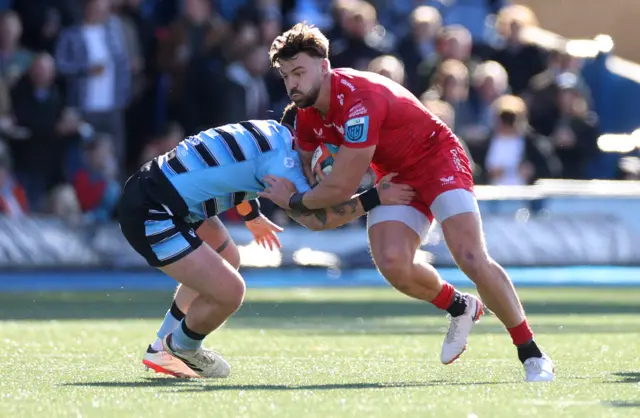 Johnny Williams of Scarlets is tackled by Ben Thomas of Cardiff