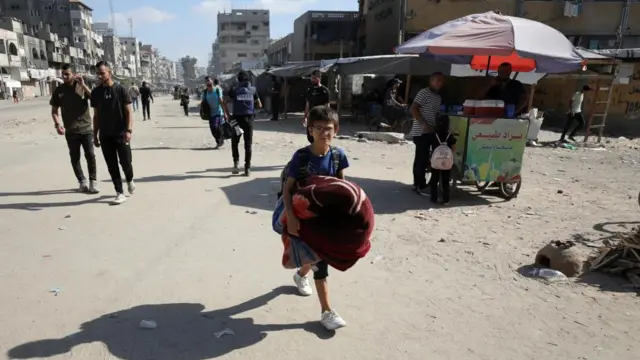 A boy carrying a blanket flees northern Gaza.