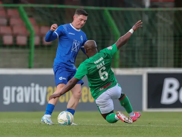 Glentoran's Fuad Sule challenges Dungannon's Thomas Maguire at the Oval