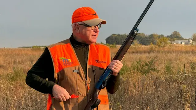 Tim Walz holds a gun