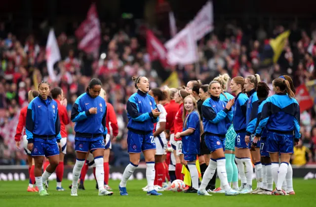 Players walk onto the pitch for the handshake