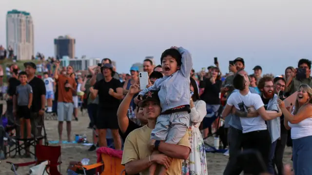 A child reacts, as people gather to observe the launch of SpaceX's Starship