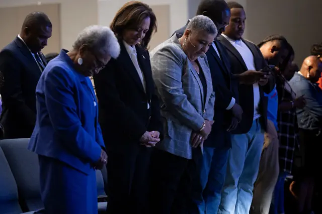 Kamala Harris (second on the left) prays a during a church service at Koinonia Christian Center in Greenville, North Carolina