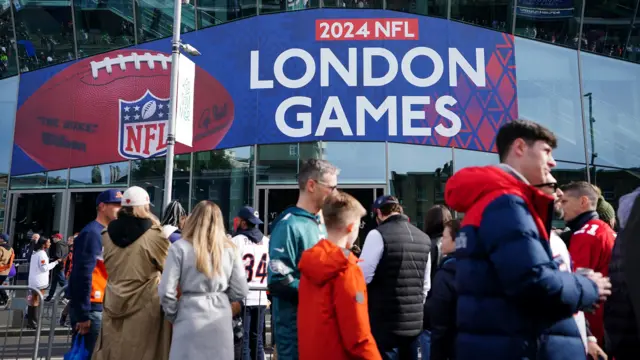 Spectators walk outside Tottenham Hotspur Stadium