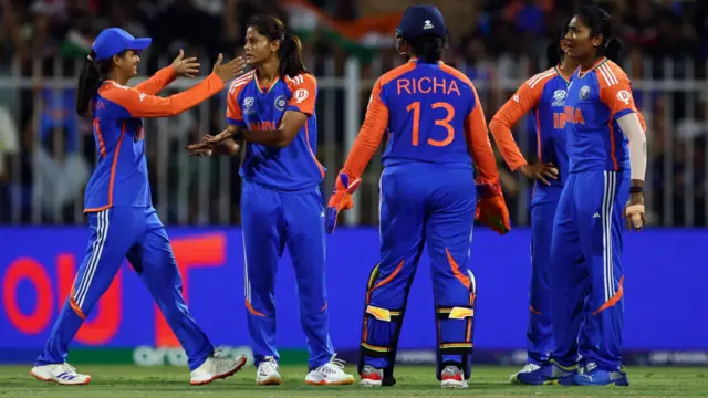 Radha Yadav of India celebrates with team mates after taking the wicket of Tahlia McGrath