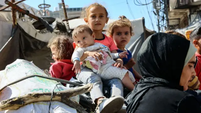 Palestinian children sit atop their family's belongings as they flee from northern Gaza