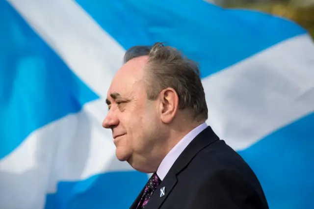 Alex Salmond in side-on profile with a saltire in the background