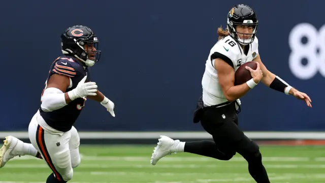 Trevor Lawrence runs with the football