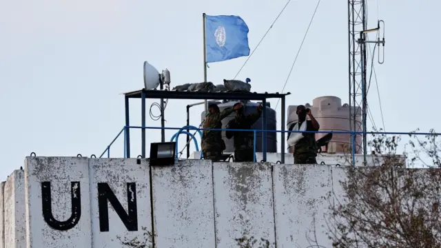 Members of the United Nations peacekeepers (UNIFIL) look at the Lebanese-Israeli border, as they stand on the roof of a watch tower ‏in the town of Marwahin, in southern Lebanon, October 12, 2023