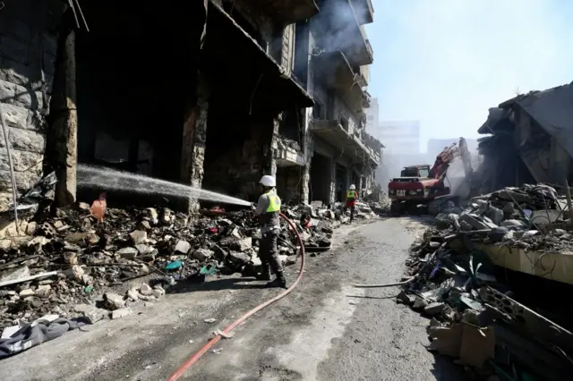 Rescuers work at the site of destroyed buildings following an Israeli strike on a commercial market in Nabatieh, southern Lebanon, on Sunday