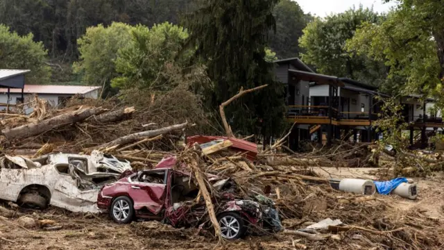 Wrecked cars lie under a mountain of debris