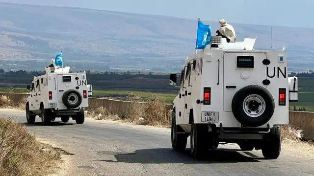 Two Unifil vehicles drive down a road