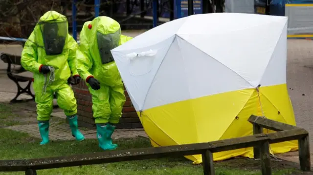 The forensic tent, covering the bench where Sergei Skripal and his daughter Yulia were found, is repositioned by officials in protective suits in the centre of Salisbury