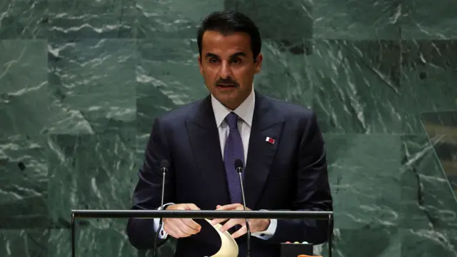 Qatar's Emir Sheikh Tamim bin Hamad Al Thani is seen at a United Nations podium in front of a green marble wall.