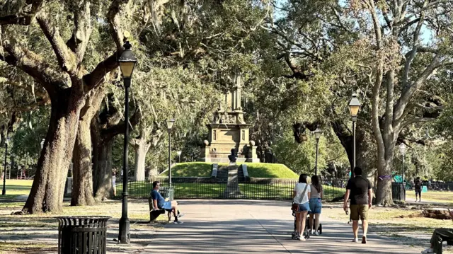 A park with people walking between trees