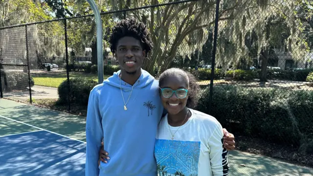 A man and woman standing next to each other on an outdoor basketball court in Georgia