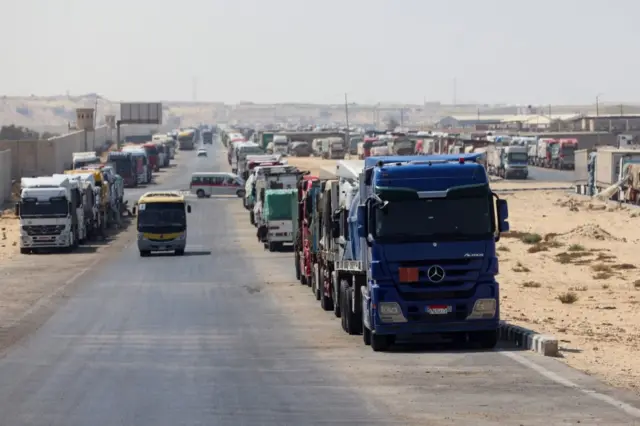 Lorries carrying aid line up near the Rafah border crossing between Egypt and the Gaza Strip