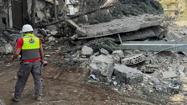 A man wearing safety helmet walks at a damaged site