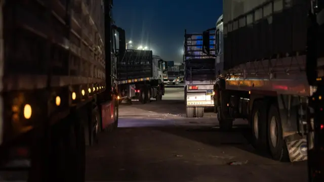 Trucks, which the IDF says are carrying humanitarian aid, wait in queue