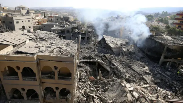 Smoke rises above the rubble in aftermath of a series of strikes on Qana in southern Lebanon