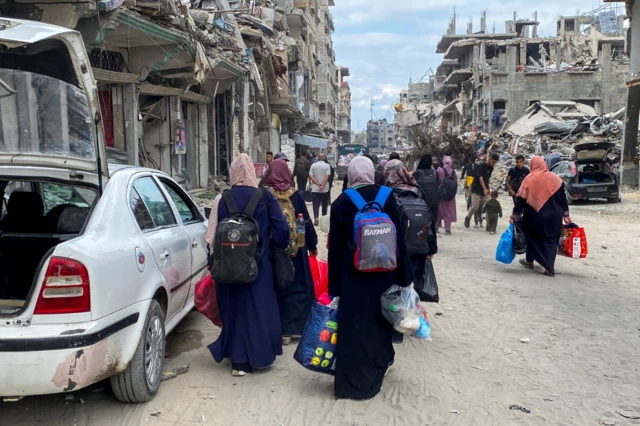 Displaced Palestinians make their way as they flee areas in northern Gaza Strip following an Israeli evacuation order