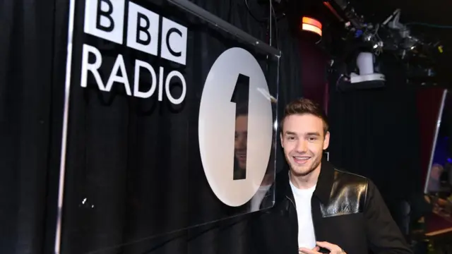 Liam Payne poses next to the BBC Radio 1 logo at BBC Studios in London