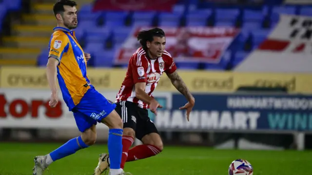 Exeter's Tristan Crama defends from Shrewsbury striker John Marquis