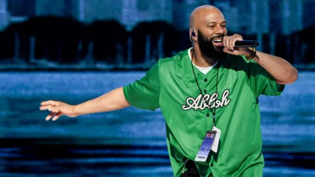 Rapper Common in a green shirt performing his track 'Fortunate' on night two of the DNC