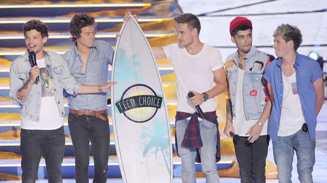 One Direction accepts the Choice Group award - which is shaped like a surfboard - at the Teen Choice Awards in 2013 in California.