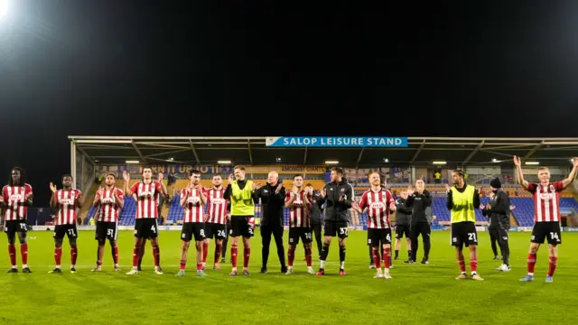 Exeter players salute the travelling supporters at Croud Meadow