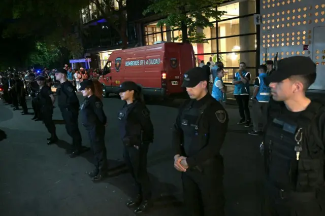 Police officers stand guard at the entrance of the Casa Sur hotel