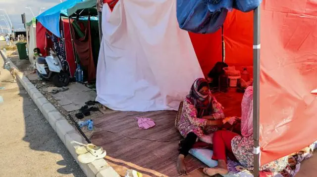 People sitting in makeshift camps on the seaside promenade in Beirut's Biel area.