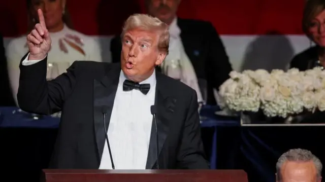 Republican presidential nominee former U.S. President Donald Trump gestures as he speaks into two microphones