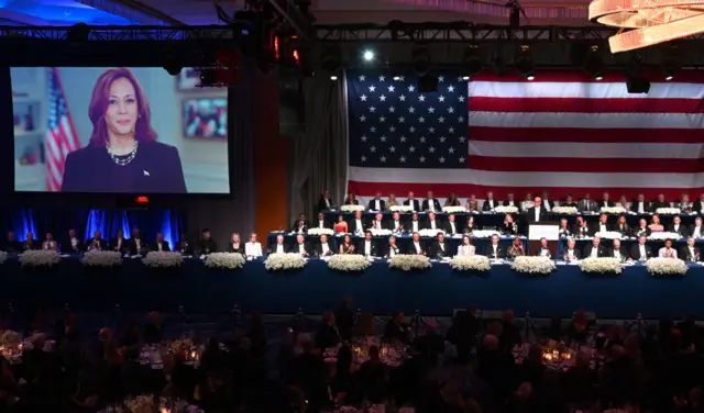 Kamala Harris appears on a screen to address guests in a pre-recorded video at the Al Smith Memorial Dinner