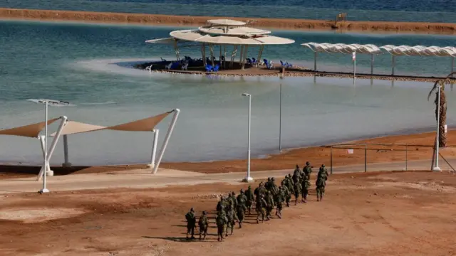 Israeli military members walk next to the Dead Sea near the scene of a shooting attack after Israel's military said it identified attackers crossing from Jordan, in southern Israel