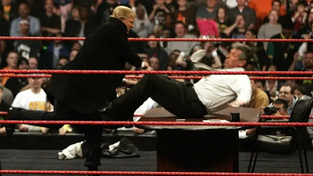 Donald Trump pushes Vince McMahon over a table in a wrestling ring during a WWE Monday Night Raw live show in 2007.