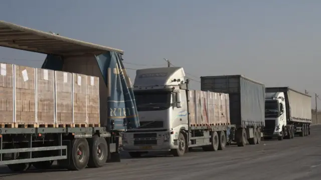 Lorries carrying humanitarian aid queued up on the side of a road