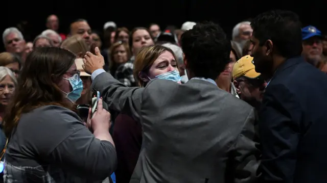 Security officials block a pro-Palestinian protester at a campaign event