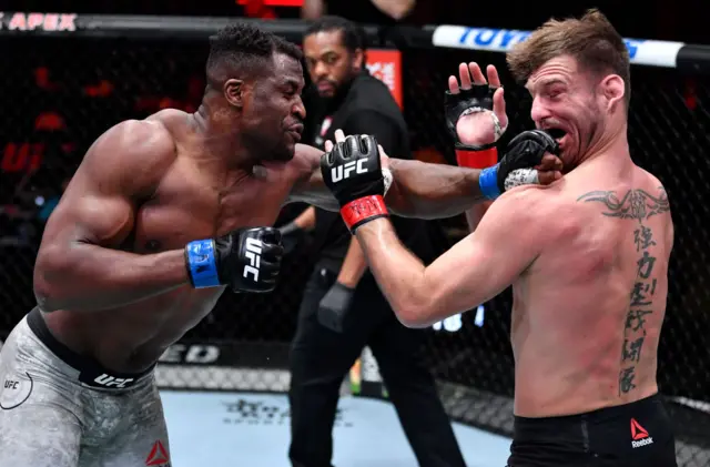 Francis Ngannou punches Stipe Miocic, making his face contort