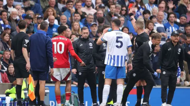 The referee handing out the red cards