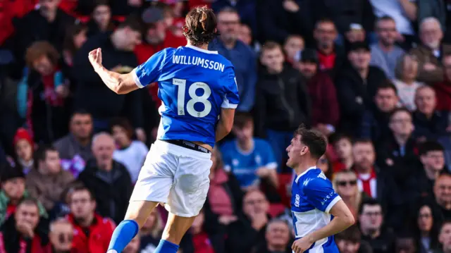 Willum Willumsson leaps into the air after scoring at Lincoln