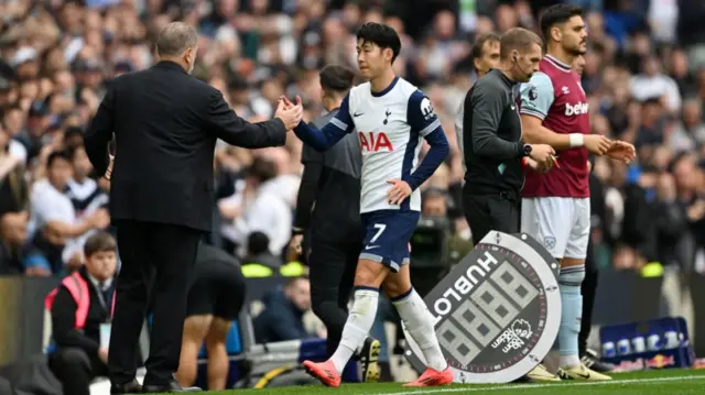 Son Heung-Min of Tottenham Hotspur with manager Ange Postecoglou upon being substituted