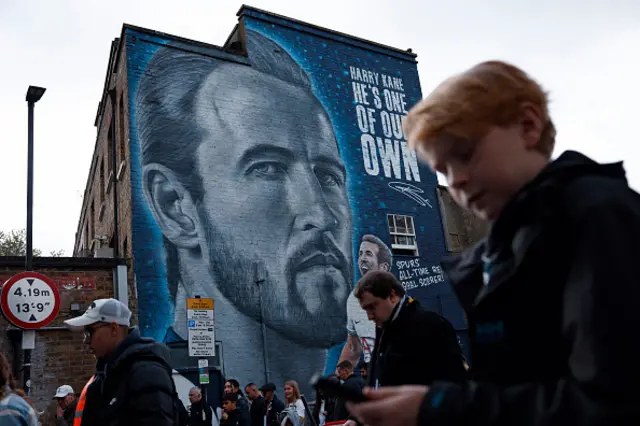 Supporters arrive near to a mural of England captain and former Spurs' striker Harry Kane