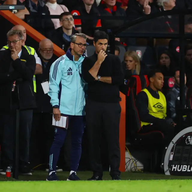 Arteta and his assistant stand deep in thought by the dugout