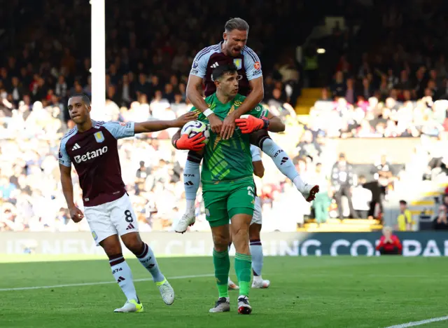 Emiliano Martinez reacts with Matty Cash after saving a penalty kick