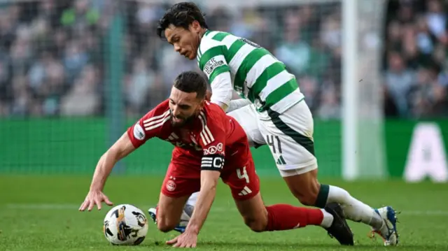 GLASGOW, SCOTLAND - OCTOBER 19: Aberdeen's Graeme Shinnie (L) and Celtic's Reo Hatate in action during a William Hill Premiership match between Celtic and Aberdeen at Celtic Park, on October 19, 2024, in Glasgow, Scotland. (Photo by Rob Casey / SNS Group)