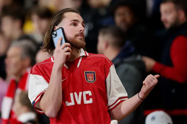 Arsenal fan on the phone in the stands