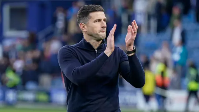 Portsmouth manager John Mousinho applauds the travelling fans after the win at QPR