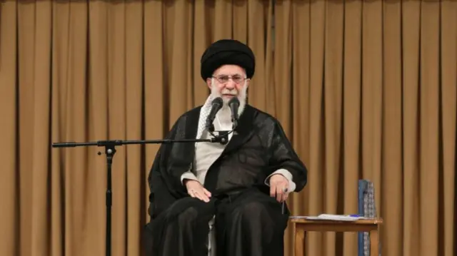 Iranian supreme leader sits on a chair on a stage