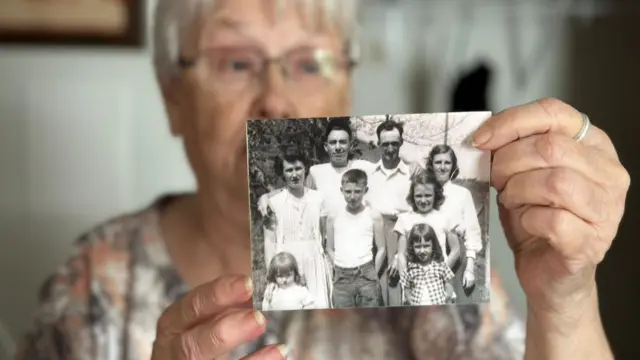 Nancy Berry holds up a family photo saved from floodwaters